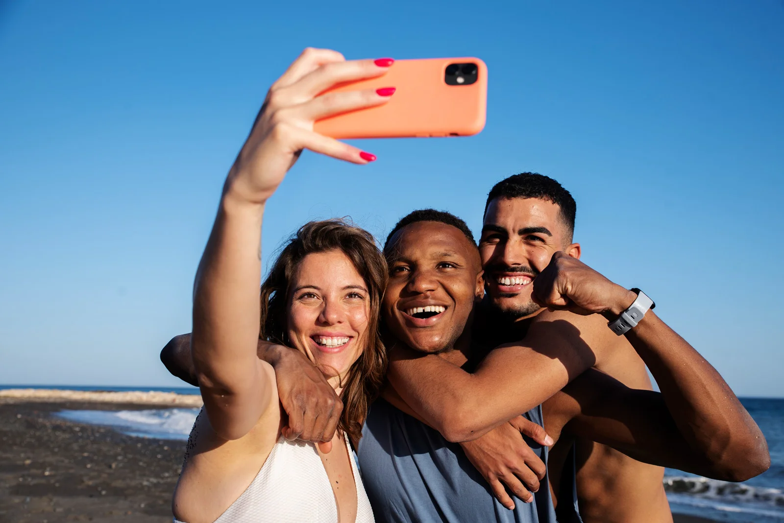 medium-shot-smiley-people-taking-selfie-beach